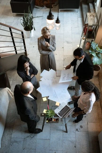 Overhead shot of diverse team analyzing marketing strategies with charts and graphs.